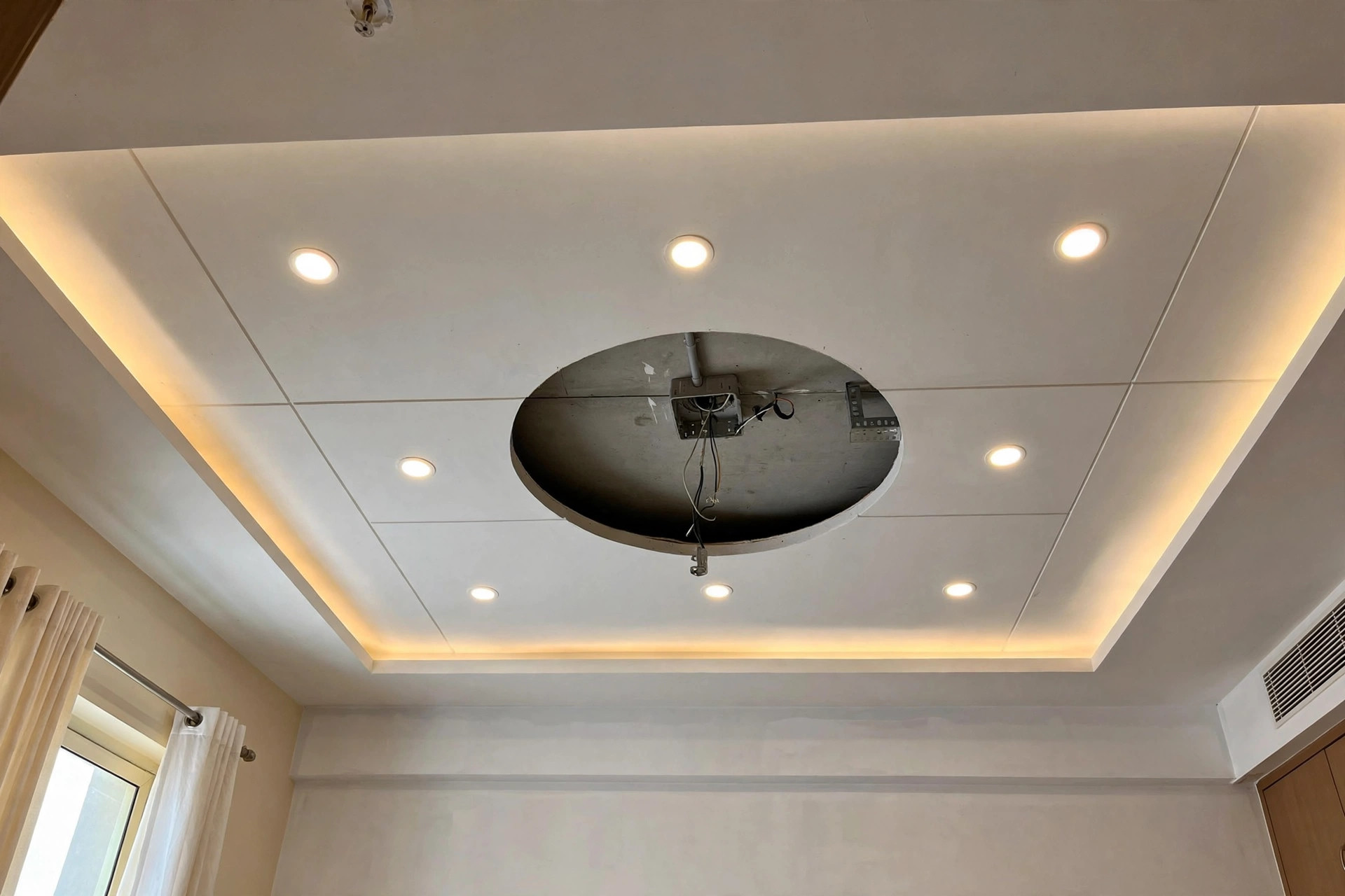 Bedroom false ceiling with a neat circular cutout for the ceiling fan