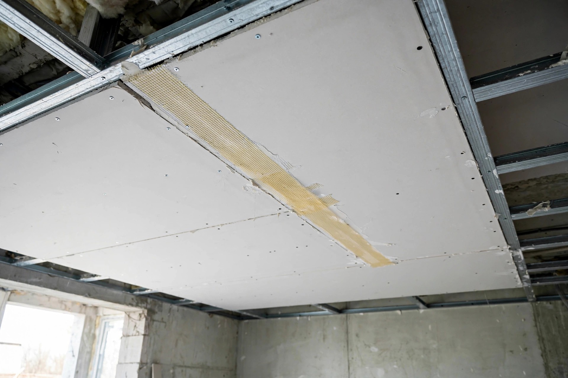 Concept render of gypsum boards being fixed to a metal frame during installation