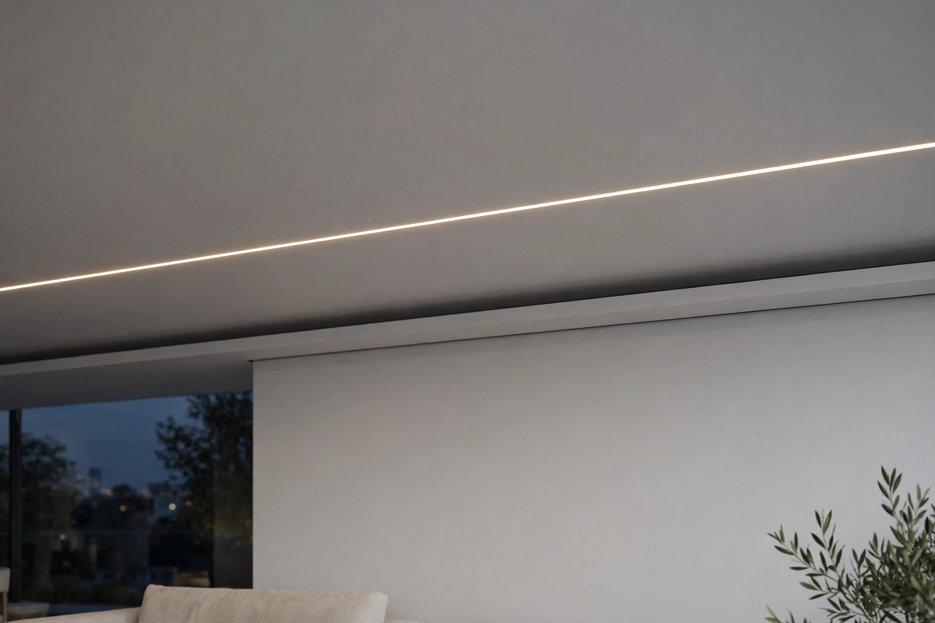 Ceiling detail with a thin recessed linear LED profile light glowing across a flat matte white ceiling