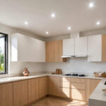 Simple Indian kitchen with a flat false ceiling and bright recessed spotlights