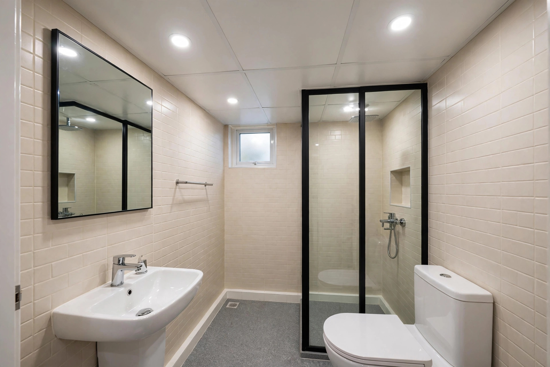 Small bathroom with a flat white PVC panel false ceiling and recessed lights