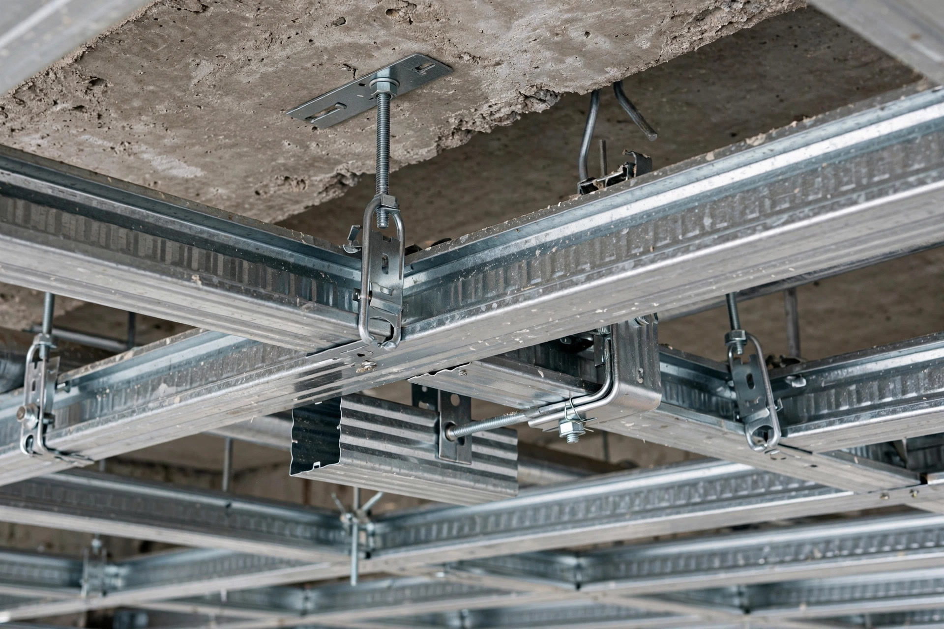 Close view of a proper metal framework for a false ceiling showing sturdy channels and hangers