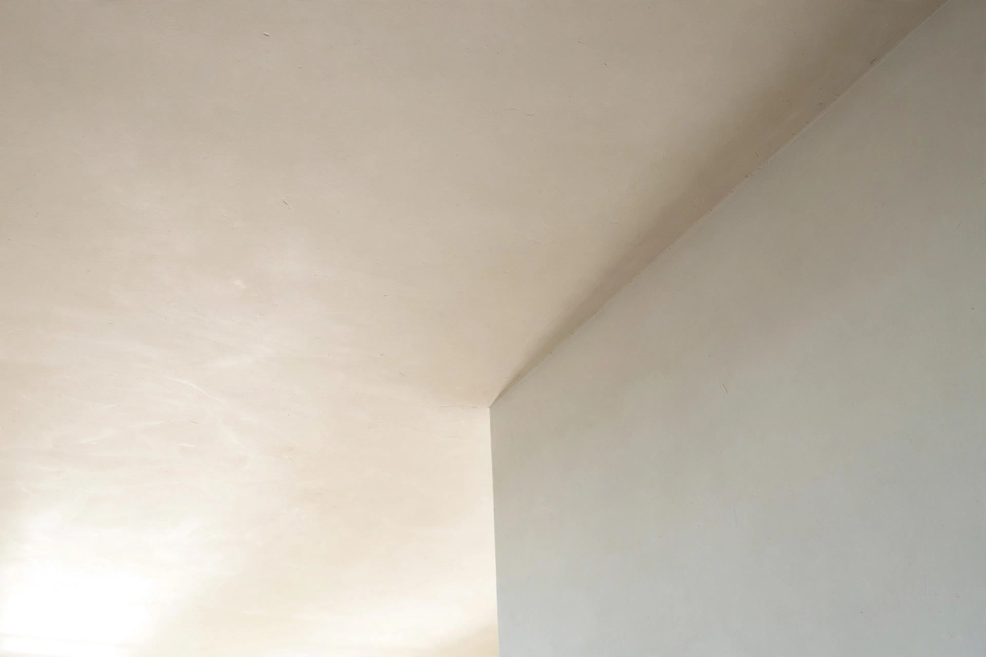 Close-up of a smooth plastered and painted ceiling meeting a wall with a crisp paint line