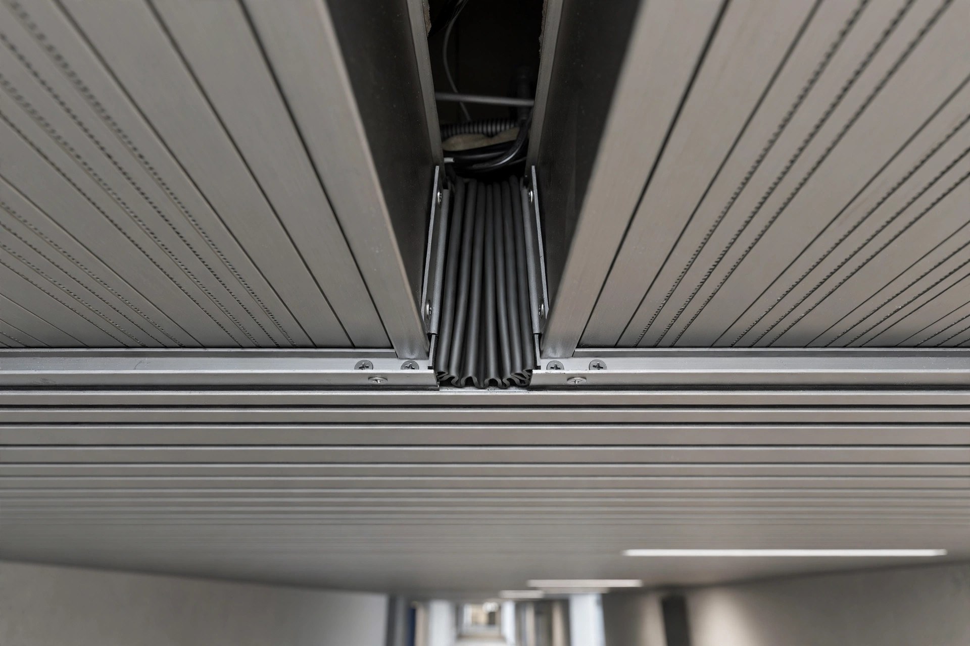 Close-up of an expansion joint in a long aluminium linear ceiling strip