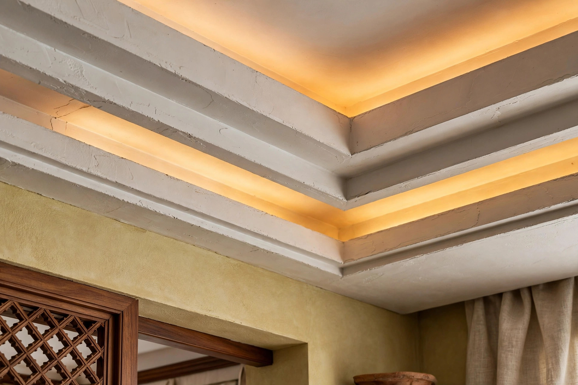 Close-up detail of a layered false ceiling edge showing two stacked cove light levels
