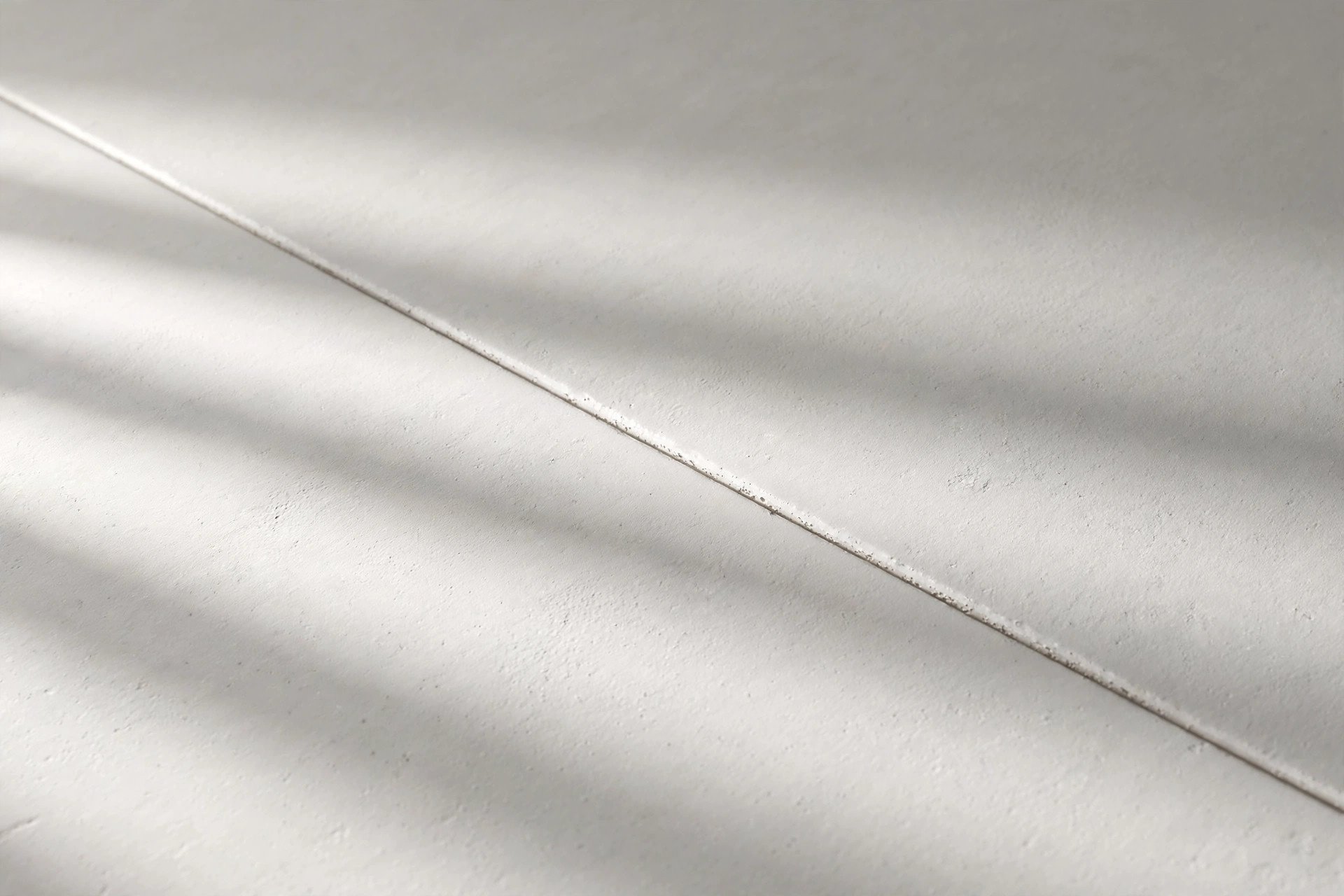 Close-up of a smooth white gypsum board false ceiling surface showing its clean flat finish