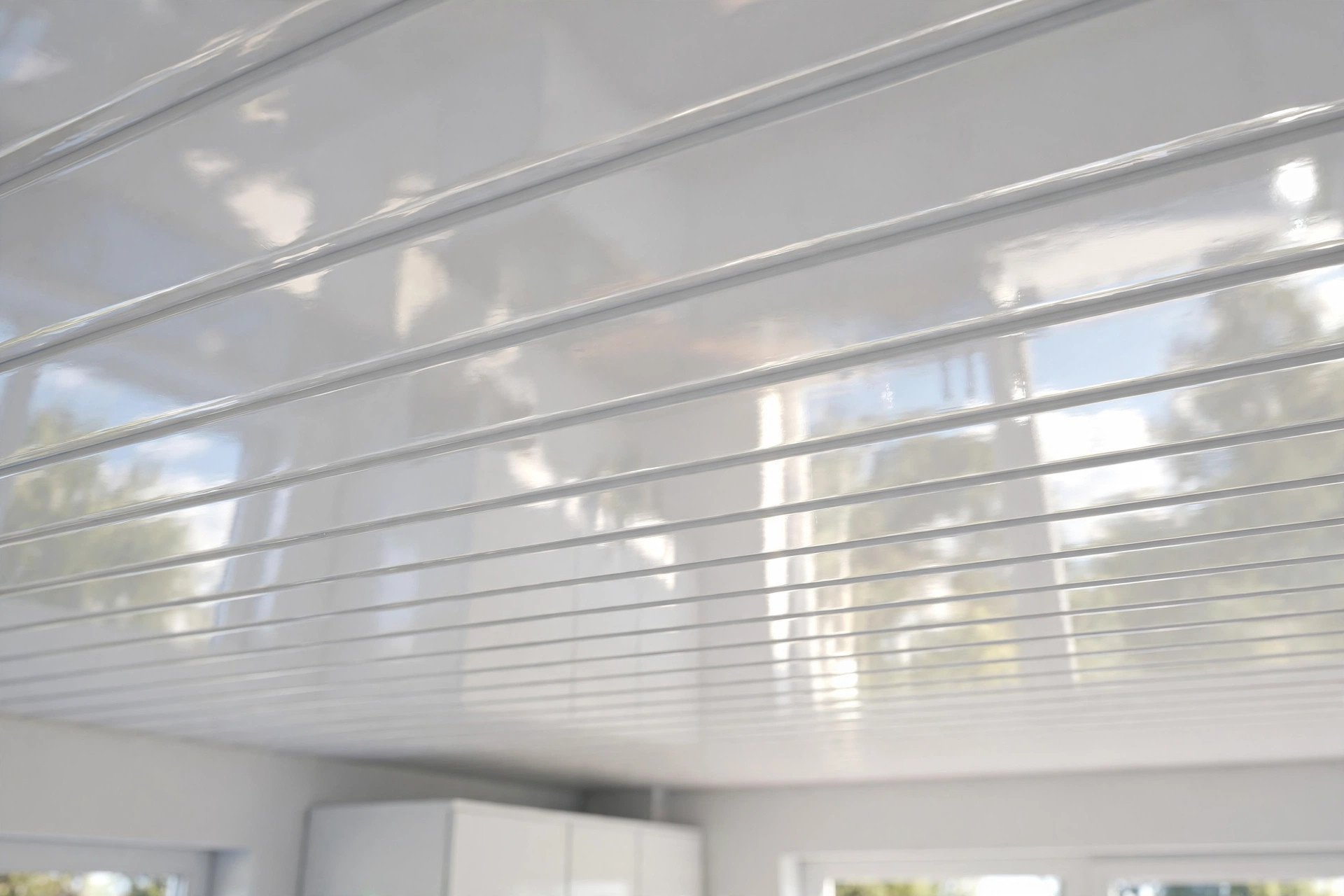 Glossy white PVC ceiling panels with groove lines installed in a bright kitchen