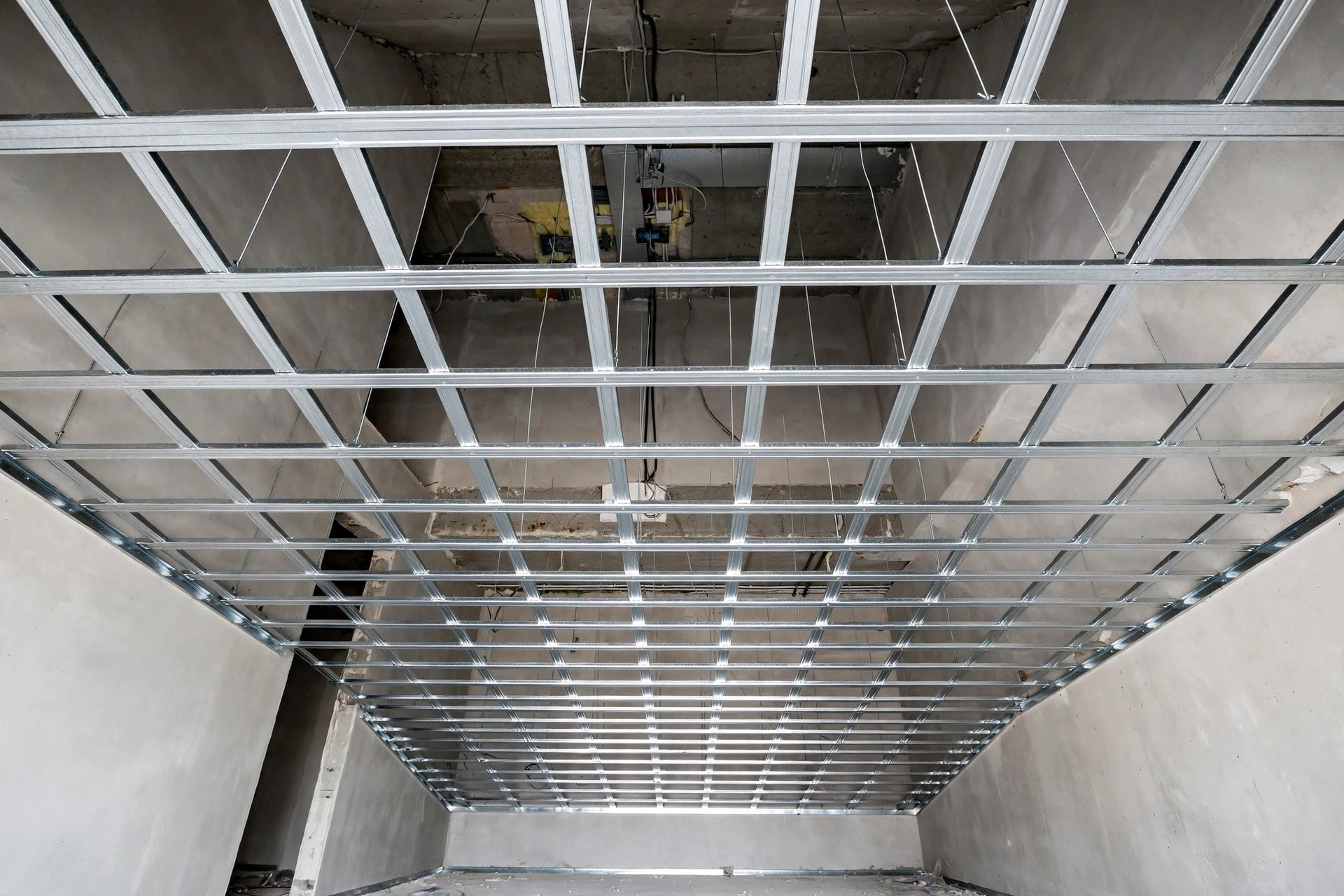 Completed metal grid of main and cross channels seen from below before boards are fixed
